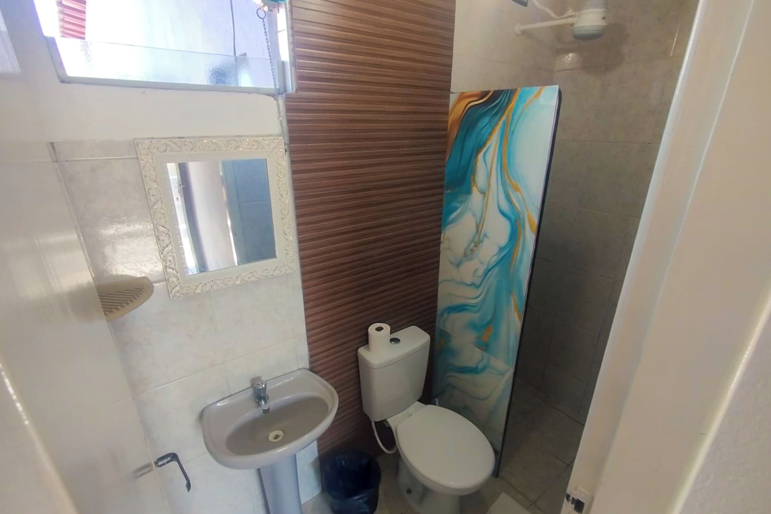 Un baño con lavamanos, inodoro y ducha.