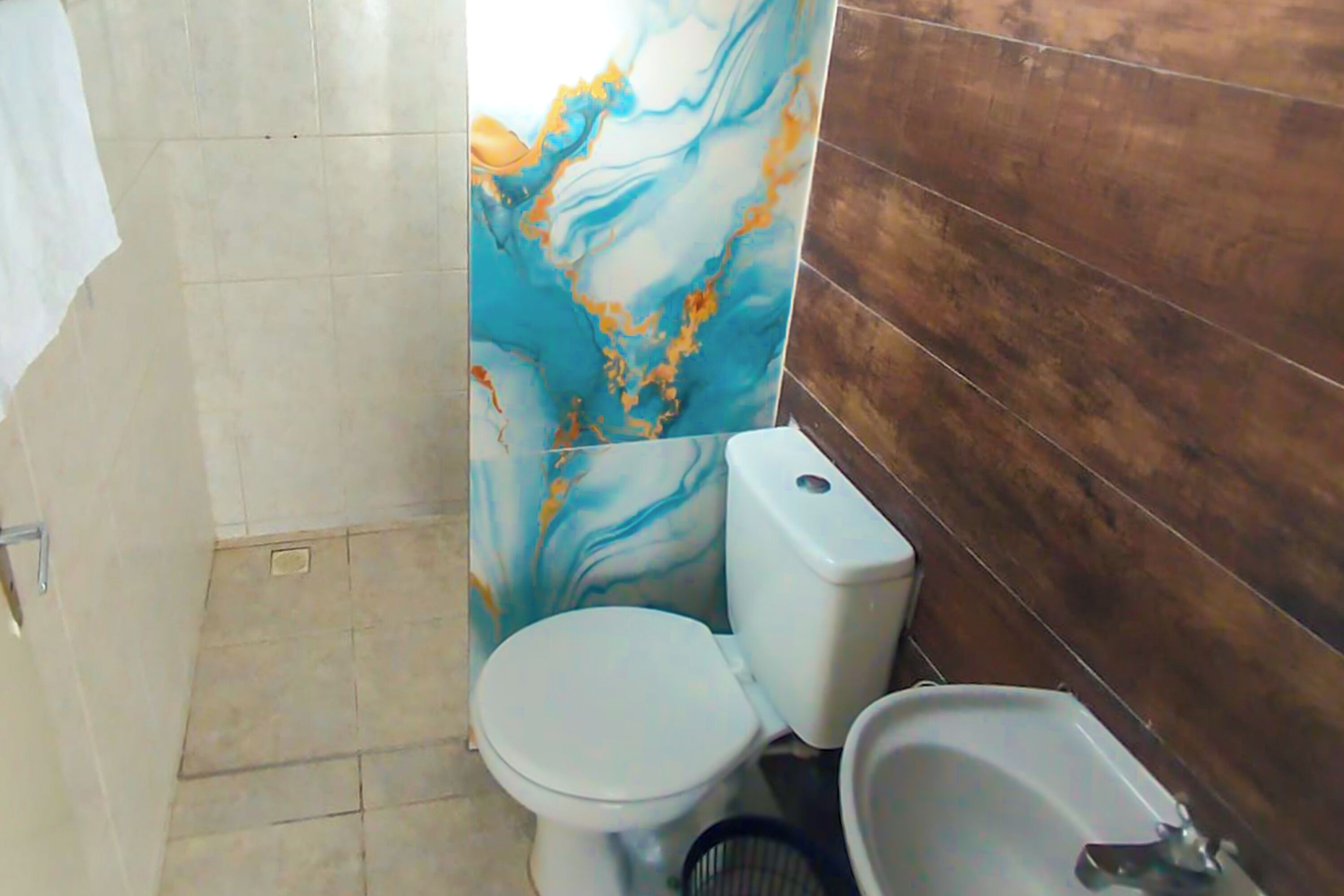 Et badeværelse med toilet, bidet og vægge af marmor.