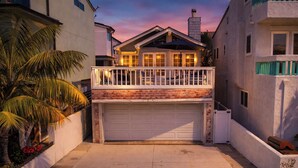 A residential property with a garage, a balcony, and a brick facade. - Perfect Newport Beach Location With Balcony & Spa (Newport Beach)