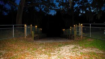 A gated pathway leading to a building surrounded by trees.