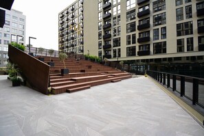 A modern building with a staircase leading to a higher floor, surrounded by other high-rise buildings. - Studio em frente a UFSC e HU - 502A (Florianópolis)