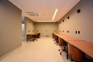 A conference room with long tables and chairs, a tiled floor, and recessed lighting. - Studio em frente a UFSC e HU - 502A (Florianópolis)