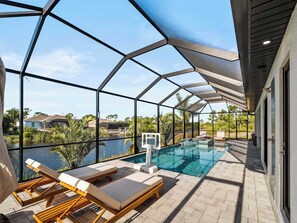 Un espace piscine avec des chaises longues et une vue sur un quartier résidentiel.
