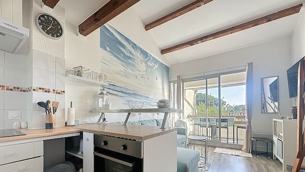 Una cocina moderna con horno empotrado, una zona de comedor con vistas y un ventanal grande.