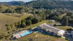 Uma casa grande com piscina, garagem e quintal cercado.