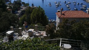 Una cittadina costiera con un porto turistico, edifici in pietra e vista sul mare.