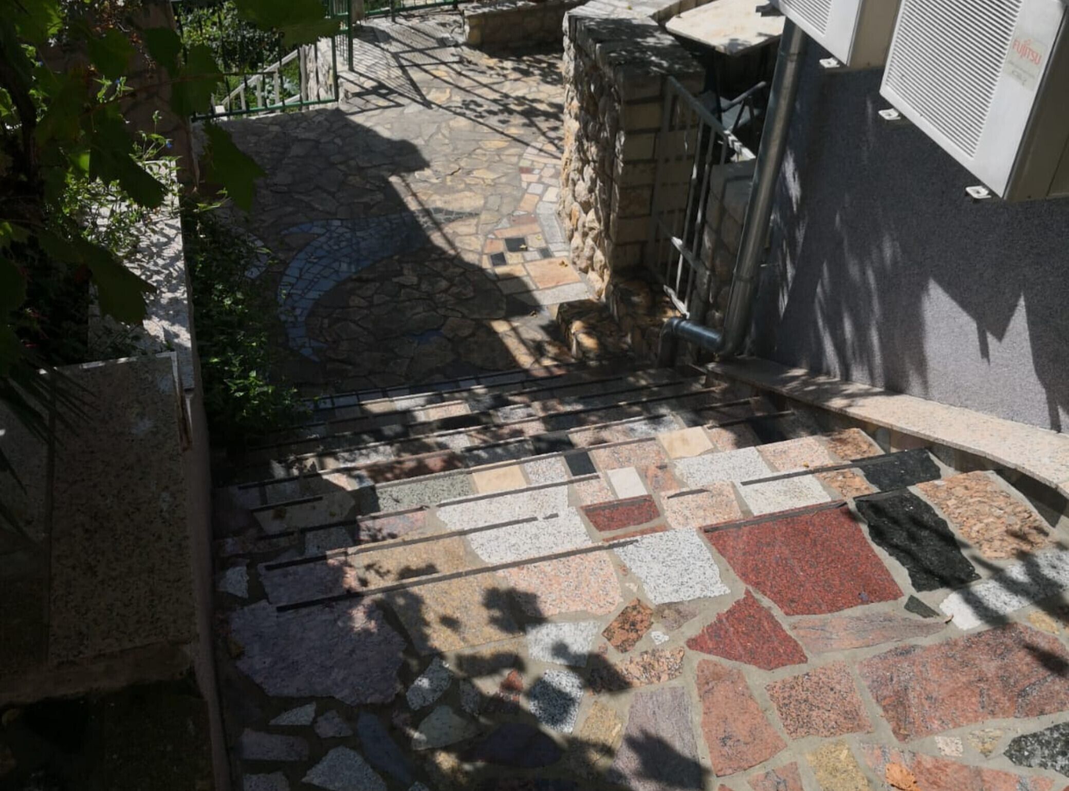 Una escalera de piedra con barandilla metálica que conduce a la entrada de un edificio.