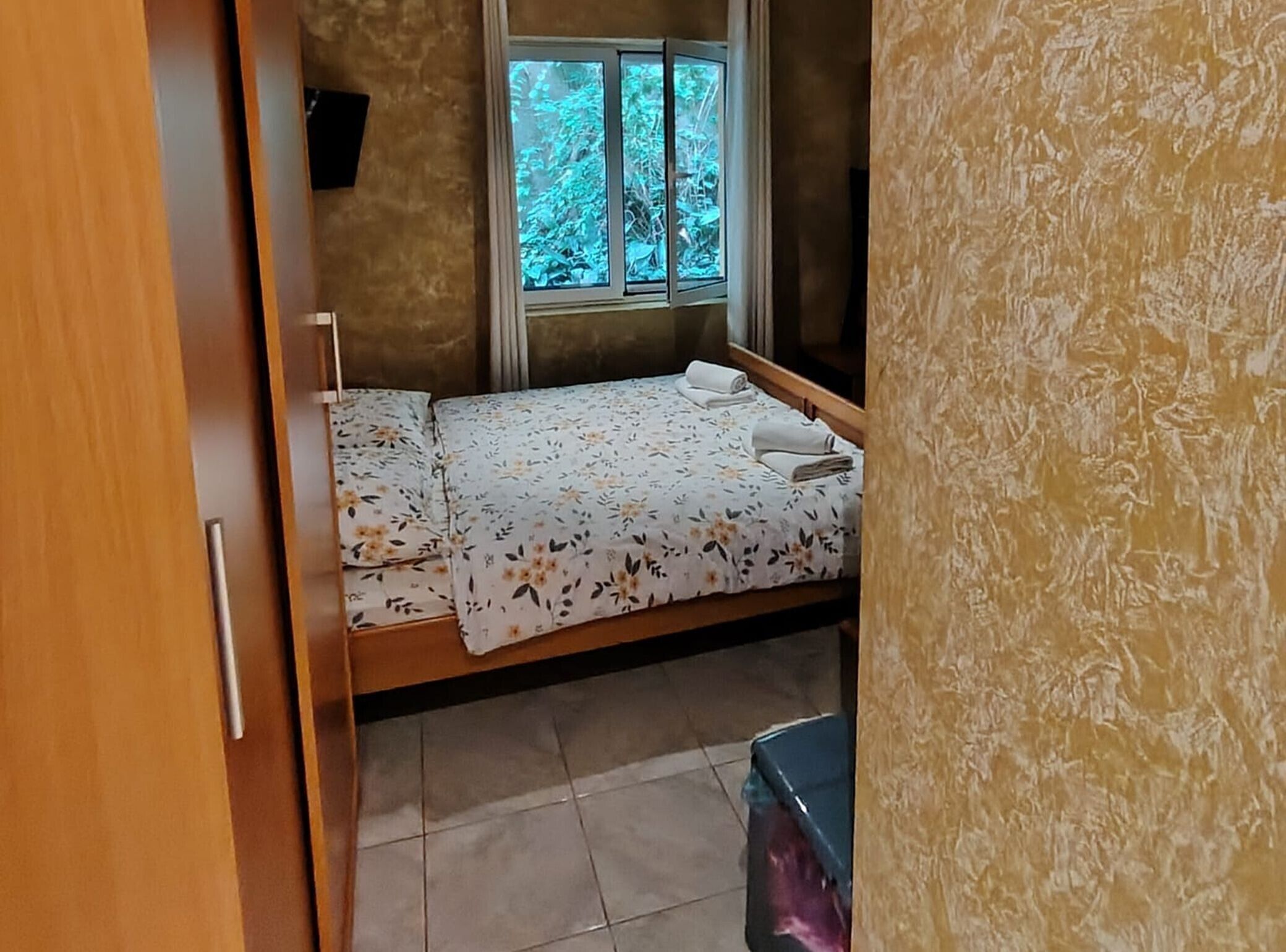 Ein Zimmer mit einem Bett, einem Fenster und einer Tür.