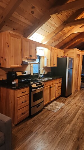 A wooden kitchen with a stove, oven, refrigerator, and wooden cabinets. - Cozy 1-bedroom cabin in charming Burnsville (Burnsville)