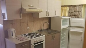 A compact kitchen with a gas stove, oven, sink, and a refrigerator. - Americana Karlobag Apartments - One Bedroom Apartment with Terrace (Karlobag)