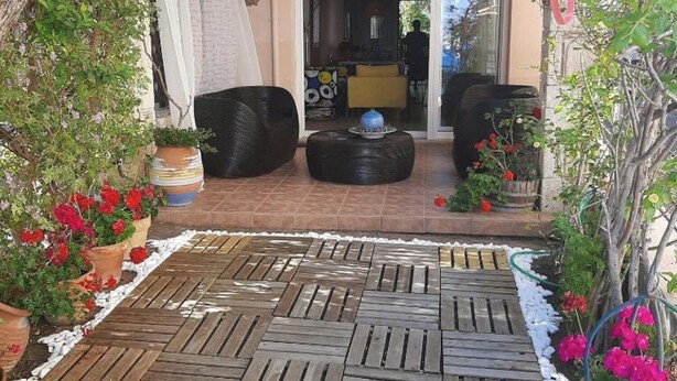 A patio with wooden decking, outdoor seating, and potted plants. - Magic mola (Chalkidiki)