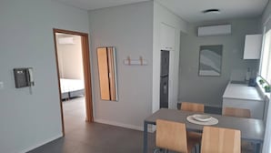 A modern kitchen with a dining table and chairs, a refrigerator, and a microwave. - Alma Rentals Sol Palermo (Buenos Aires)