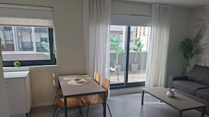 A modern living room with a dining table, chairs, a sofa, and a coffee table. - Alma Rentals Sol Palermo (Buenos Aires)