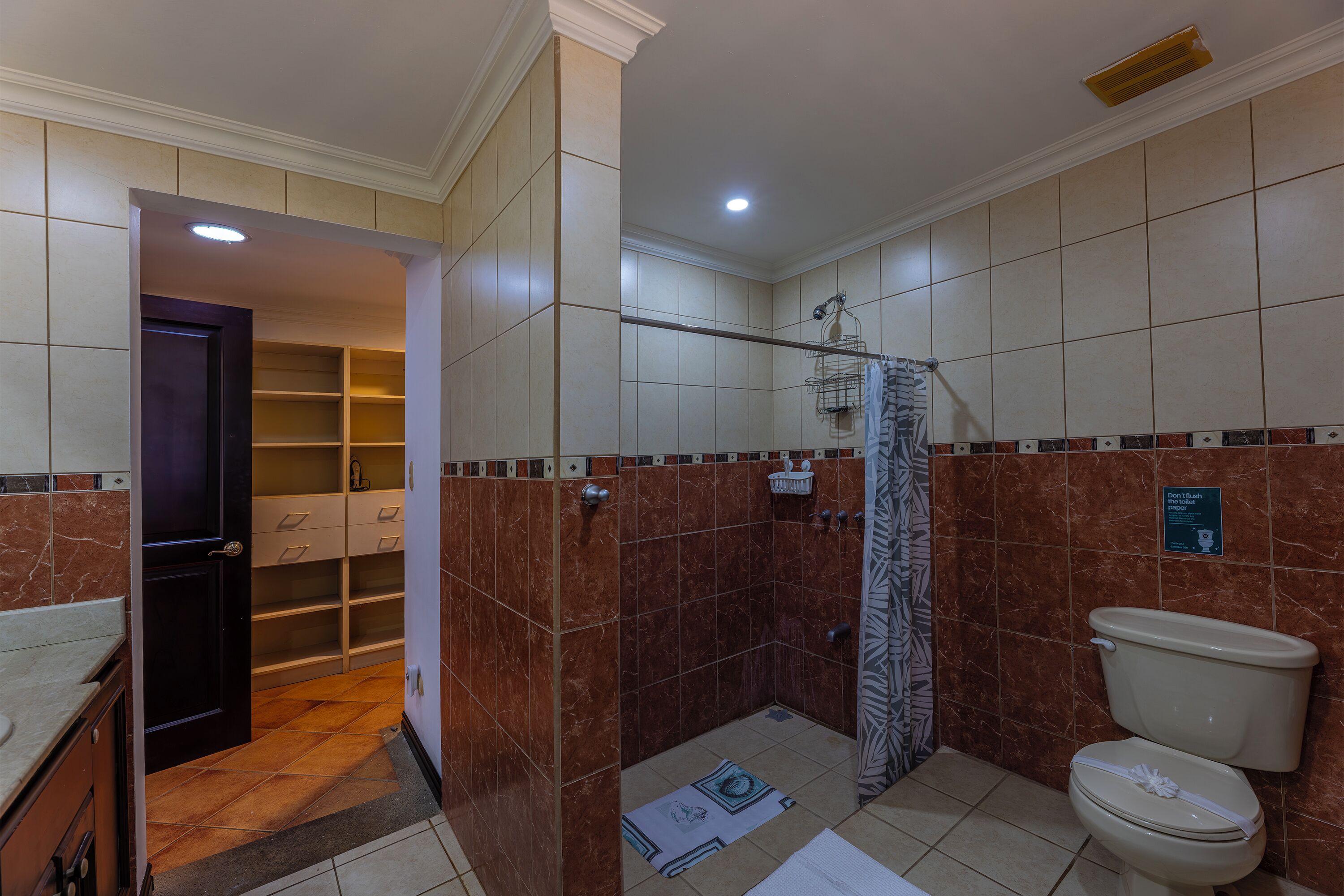 Une salle de bain équipée d’une douche, de toilettes et de meubles de rangement.