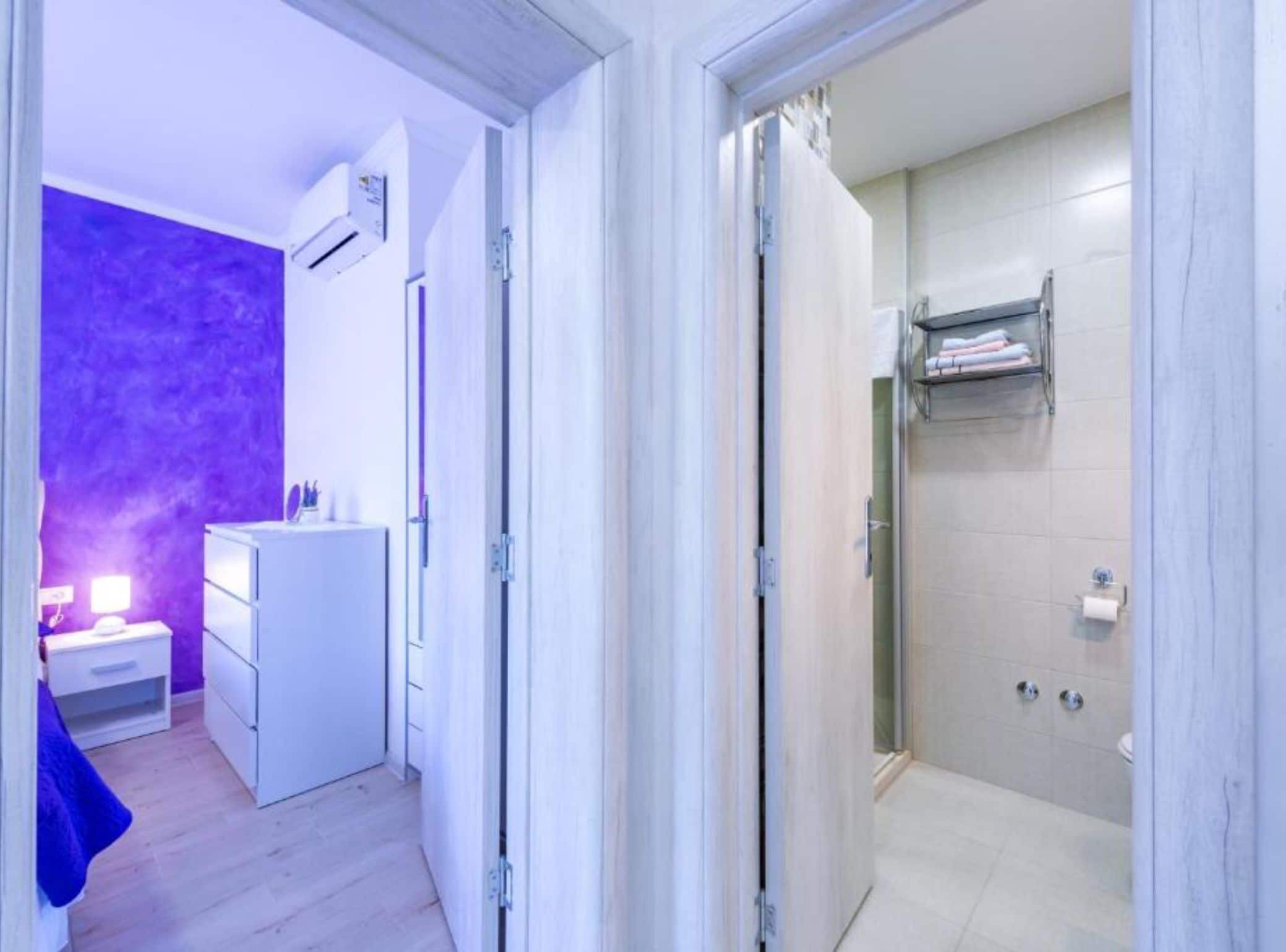 Een moderne badkamer met een douche, toilet en een handdoekhouder.