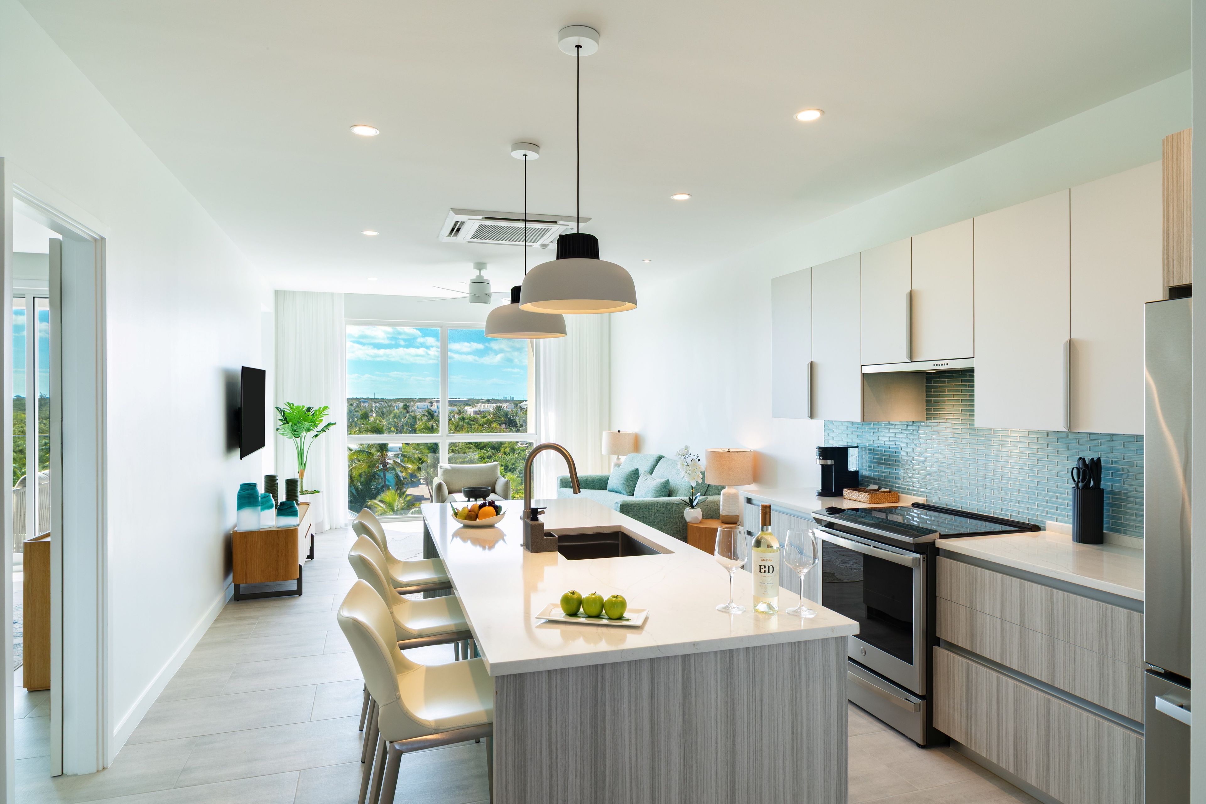 A modern kitchen with a central island, stainless steel appliances, and a view to the outdoors.