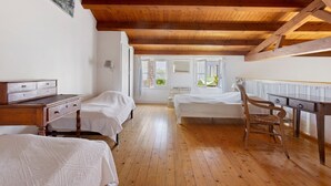 A room with wooden beams, two beds, a desk, and a chair. - “Maison De Pays Églantine” with Private Terrace, Garden, and Wi-Fi (Sainte-Marie-de-Ré)