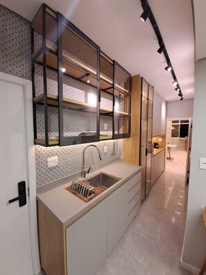 Eine moderne Küche mit integriertem Spülbecken, Holzschränken und einer gemusterten Spritzschutzwand.