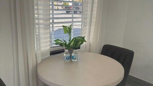 Et rundt bord med to stole, en potteplante og to vandflasker.