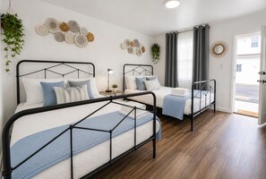 Ein Hotelzimmer mit zwei Betten, einem kleinen Tisch, einer Lampe und Wanddekoration.