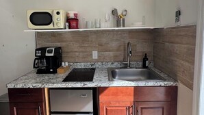 A compact kitchen with a microwave, coffee maker, and a sink. - Studio 3 miles from the Beach, with pool #512 (Belleair)