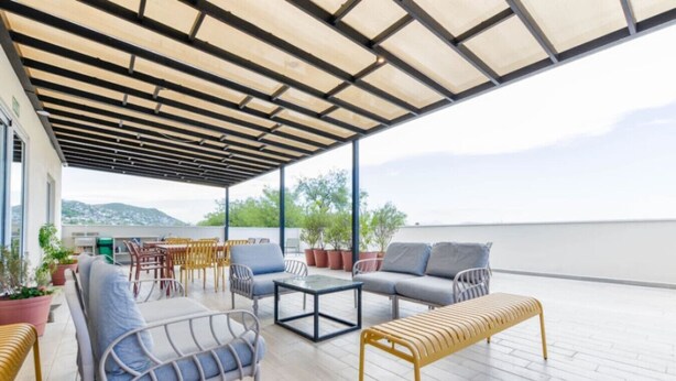 An outdoor patio with seating, a table, and potted plants. - 1G Casa Curie Coliving - Cama Matrimonial + Wifi (Monterrey)
