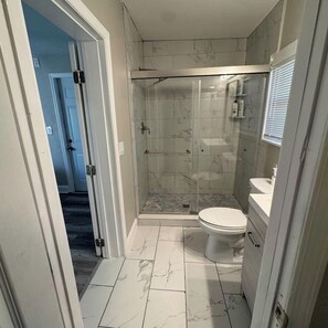 Un baño con ducha, inodoro y lavamanos.
