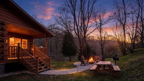 Eine Blockhütte mit Veranda, Feuerstelle und Picknicktisch.