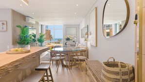 A modern kitchen with a dining area, a large mirror, and a view to the outside. - 2 Bed Beachfront Home with Panoramic Sea Views - Steps from the Beach (Cape Town)