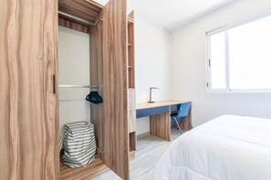 A bedroom with a bed, a desk, and a wardrobe. - 1F Casa Curie Coliving - Cama Matrimonial + Wifi (Monterrey)