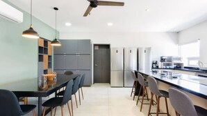 Eine moderne Küche mit einer zentralen Kochinsel, dunklen Stühlen und einem Deckenventilator.