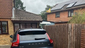 Un Volvo XC40 negro estacionado en una entrada de casa.