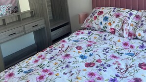 Un dormitorio con cama, cómoda, espejo y armario.
