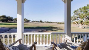 A porch with white railings and two wooden chairs with cushions. - Unique Victorian Home*Pool*Pets*Firepit (Dripping Springs)