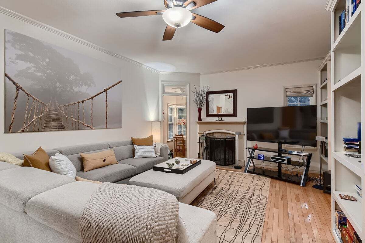 A living room with a sofa, coffee table, TV, fireplace, and bookshelves.