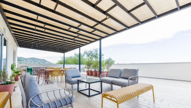An outdoor patio with seating, a table, and potted plants. - 1B Casa Curie Coliving - Cama Matrimonial + Wifi (Monterrey)