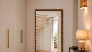A hallway with a large mirror, a lamp, a small table with a candle, and a woven basket. - Duplex with panoramic terrace - Centre, Saint-Paul-de-Vence - Air conditioning & WiFi (Saint-Paul-de-Vence)