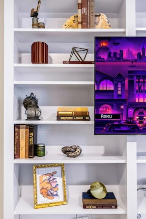 Ein Bücherregal mit Büchern, Dekoration und einem gerahmten Bild.
