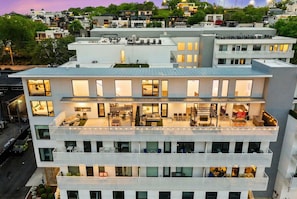 A multi-story building with balconies, large windows, and a rooftop terrace. - Fall Nashville stay: Gulch condo with private skyline deck & pool, sleeps 8 (Nashville)