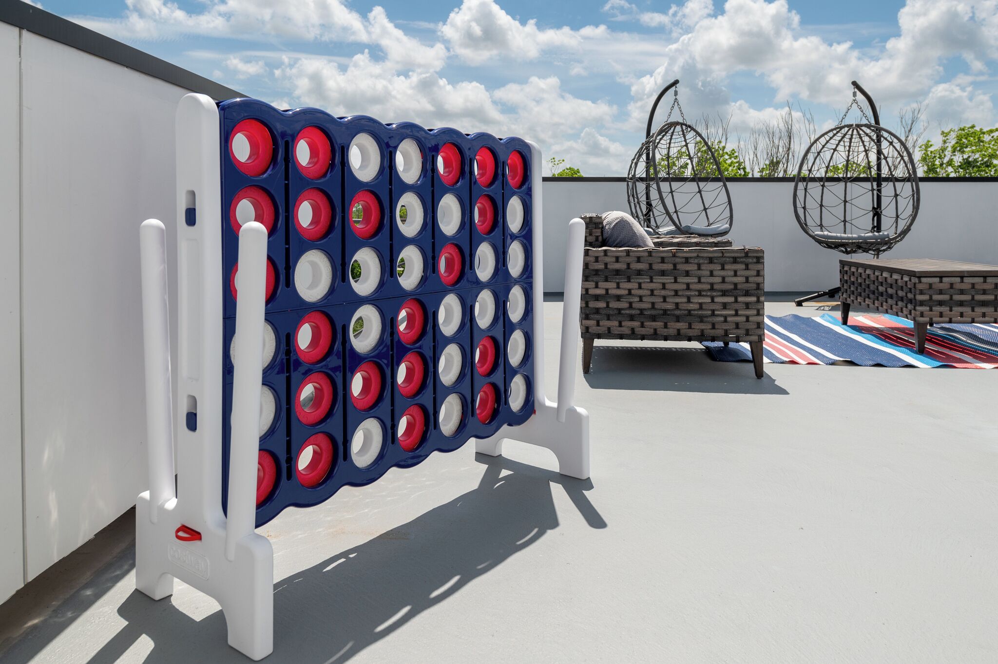 A patio area with a bean bag seating, a bean bag swing, and a bean bag table.