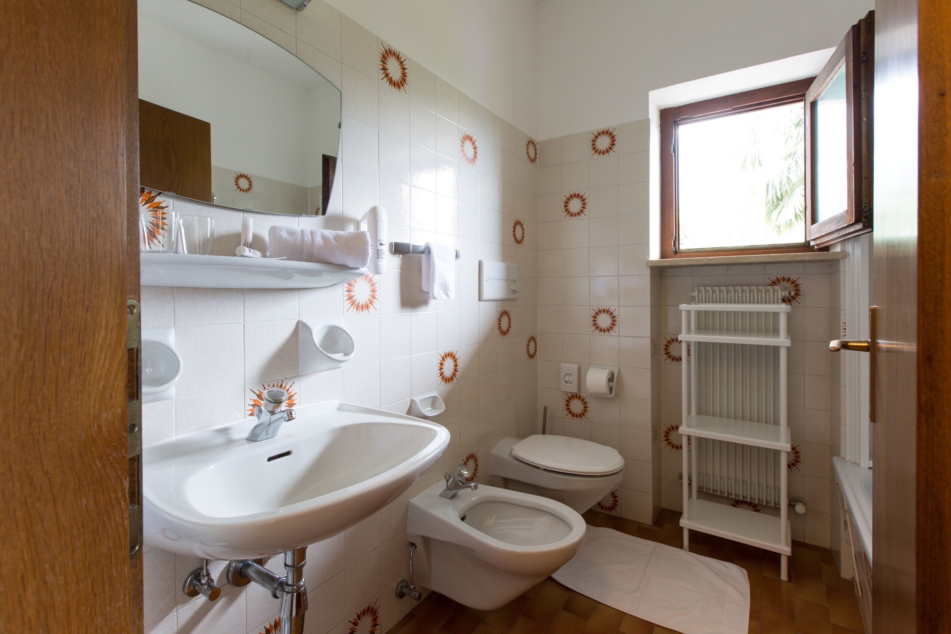 Ein Badezimmer mit Waschbecken, Bidet, Toilette und Fenster.