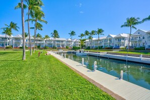 A waterfront hotel with multiple-story buildings, a dock, and palm trees. - Lux Waterfront Villa 24: Priv. Boat Slip, Boat Ramp Access, Gulf Views, Pool (Marathon)