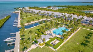 Luchtbeeld van een resort met een zwembad, aangemeerde boten en een jachthaven.