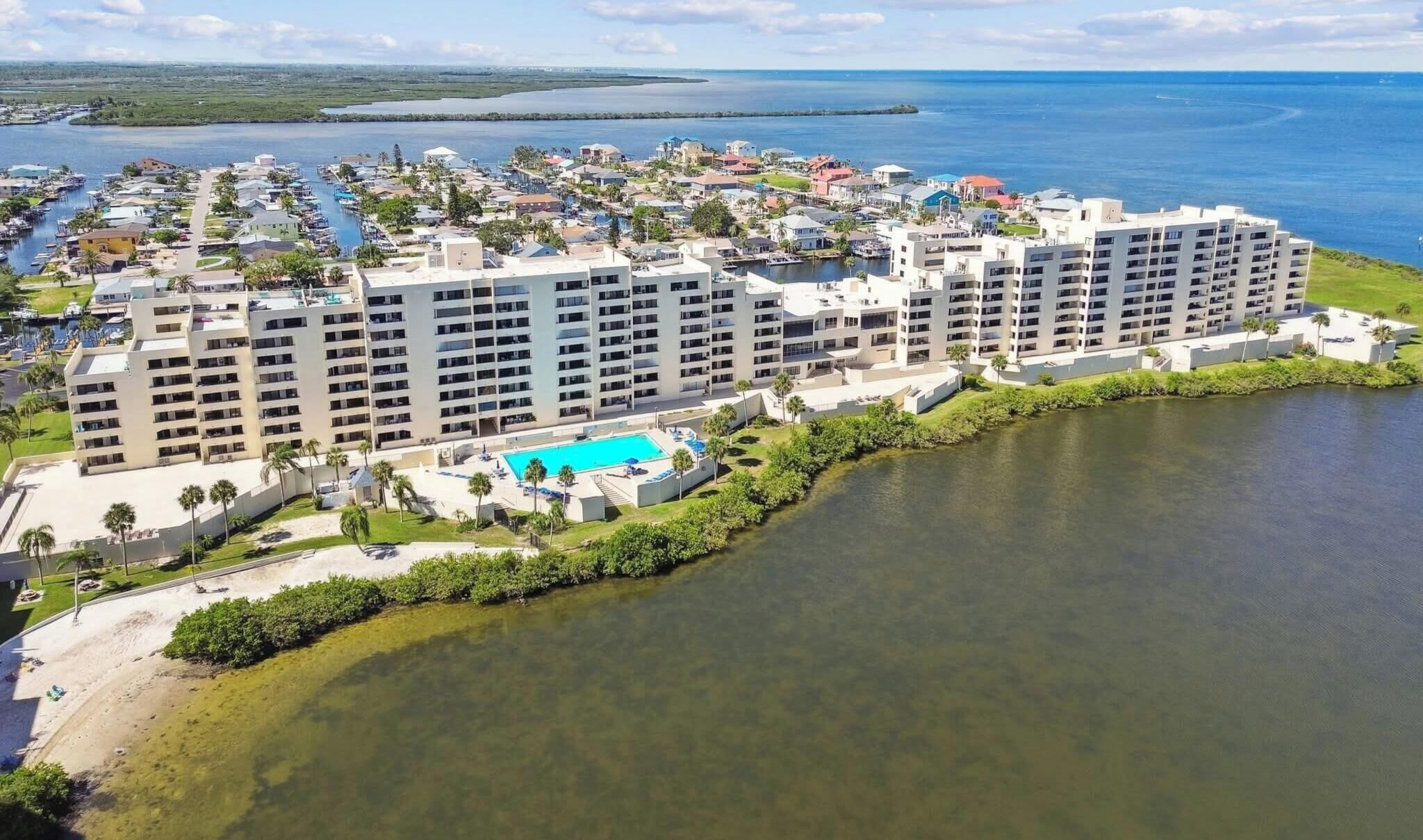Un hotel de varios pisos con piscina, situado cerca del agua.