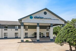 A hotel with a modern design, featuring a covered entrance and a clear sky.