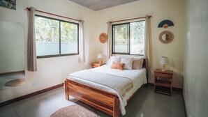 A bedroom with a bed, two bedside tables, a ceiling fan, and large windows. - Mahali 2: House with 2 bedrooms in Puerto Viejo (Puerto Viejo de Talamanca)
