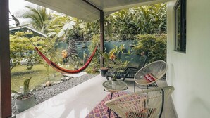 A balcony with a hammock, wicker chairs, potted plants, and a view of a lush garden. - Mahali 2: House with 2 bedrooms in Puerto Viejo (Puerto Viejo de Talamanca)