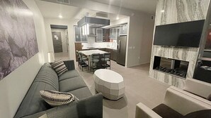 Un salon moderne avec un canapé, une table basse ronde et une cheminée.