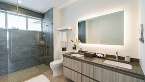 Ein modernes Badezimmer mit Dusche, Toilette und Waschtisch mit großem Spiegel.