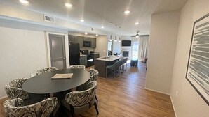 A modern kitchen with a dining area, a built-in oven, and a large window. - Moab | Desert Basecamp Retreat | Pool + Hot Tub | 2BR (Moab)
